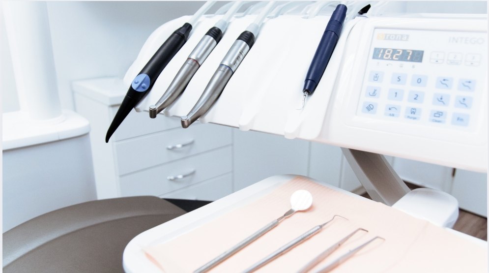 Handpieces on a delivery unit with instruments on the tray